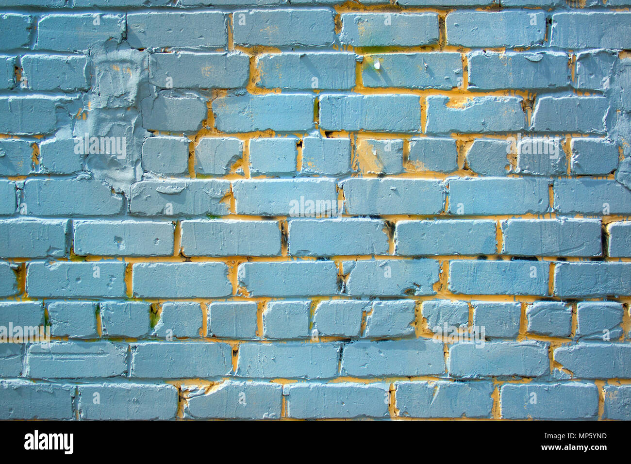 Blue old painted bricks wall texture with yellow Stock Photo