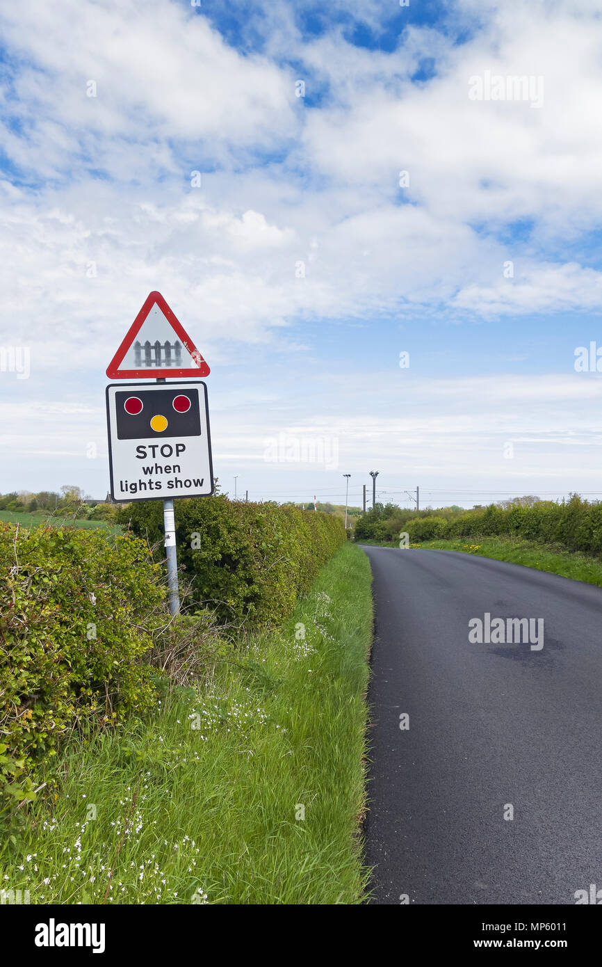 Road traffic sign warning of approaching level crossing and possible need to stop at Warkworth in Norhumberland, UK Stock Photo