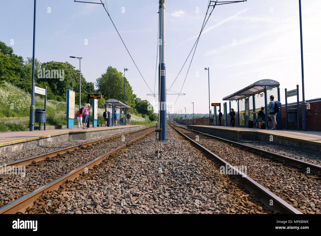 The tram stop at Sheffield railway station. People are waiting on both platforms. Stock Photo