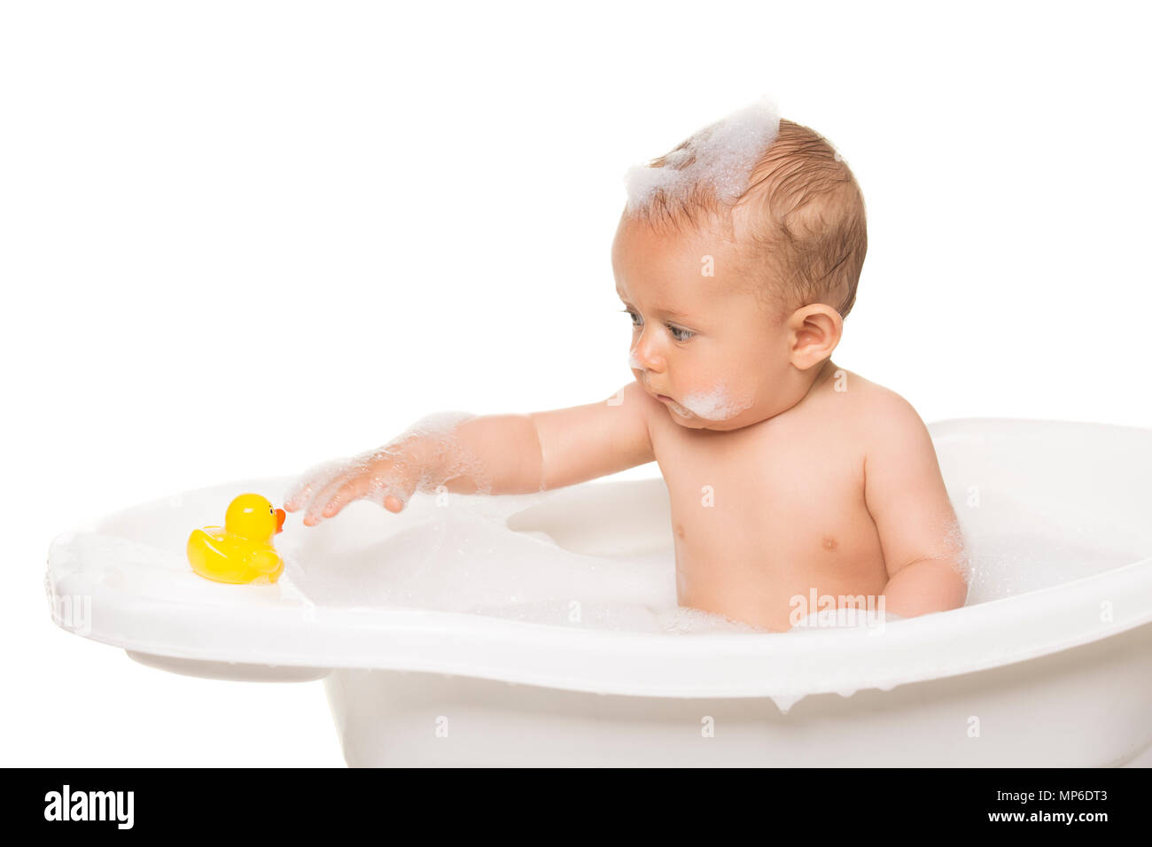 Adorable caucasian baby boy in a white bathtub with bubble bath. The