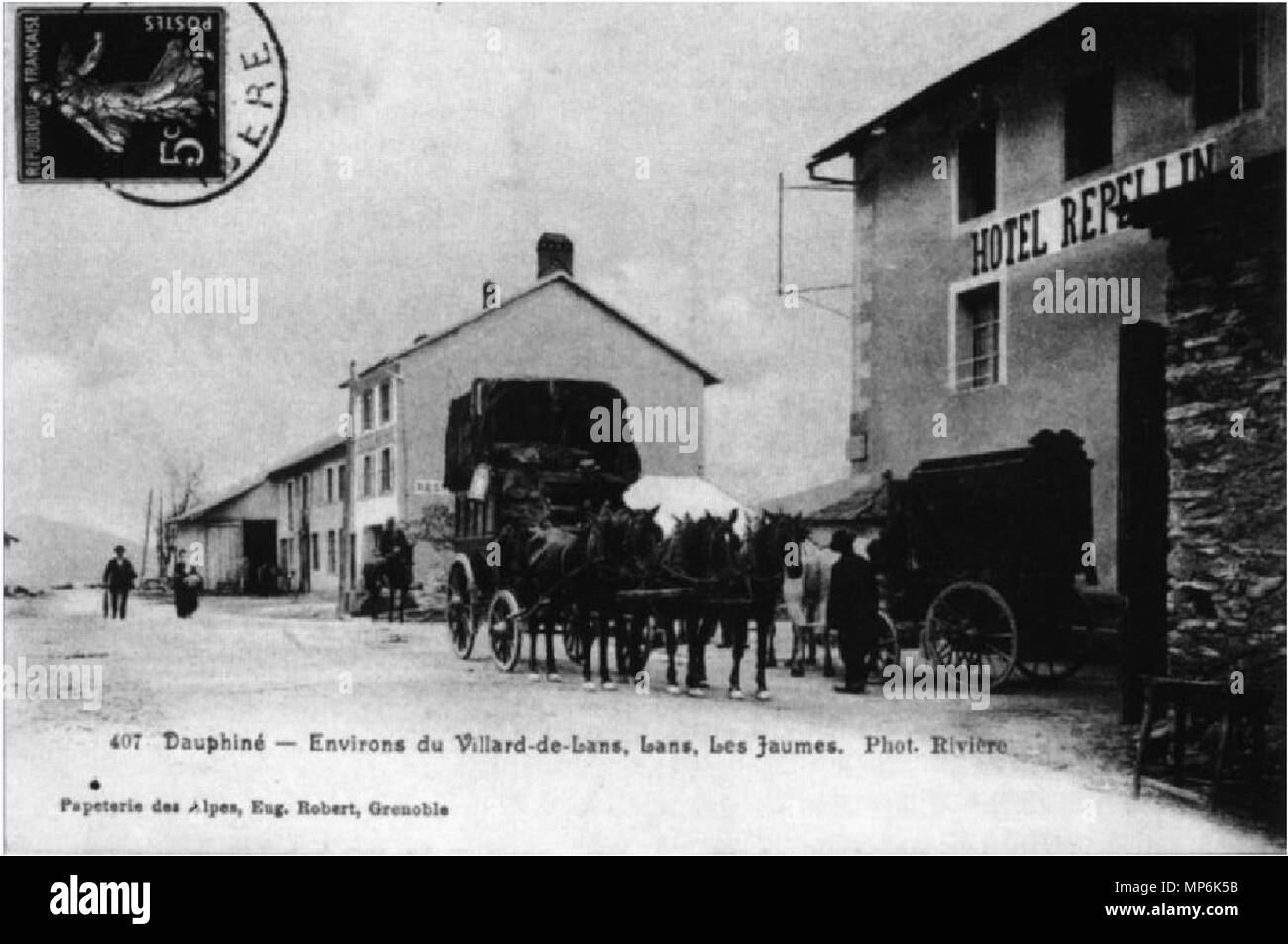 . A dirt road is bordered on one side of five houses with one or two floors. One of them, with two floors, have the sign of an hotel. Behind it are two stagecoaches. They carry passengers. The coachman's seat is occupied by two people on one and the other remains free . circa 1900. Rivière 963 Pataches. Lans-en-Vercors. Relais de Jaume Stock Photo