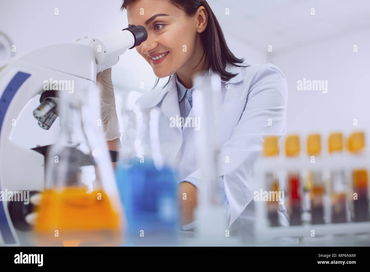 Exuberant researcher looking into the microscope Stock Photo