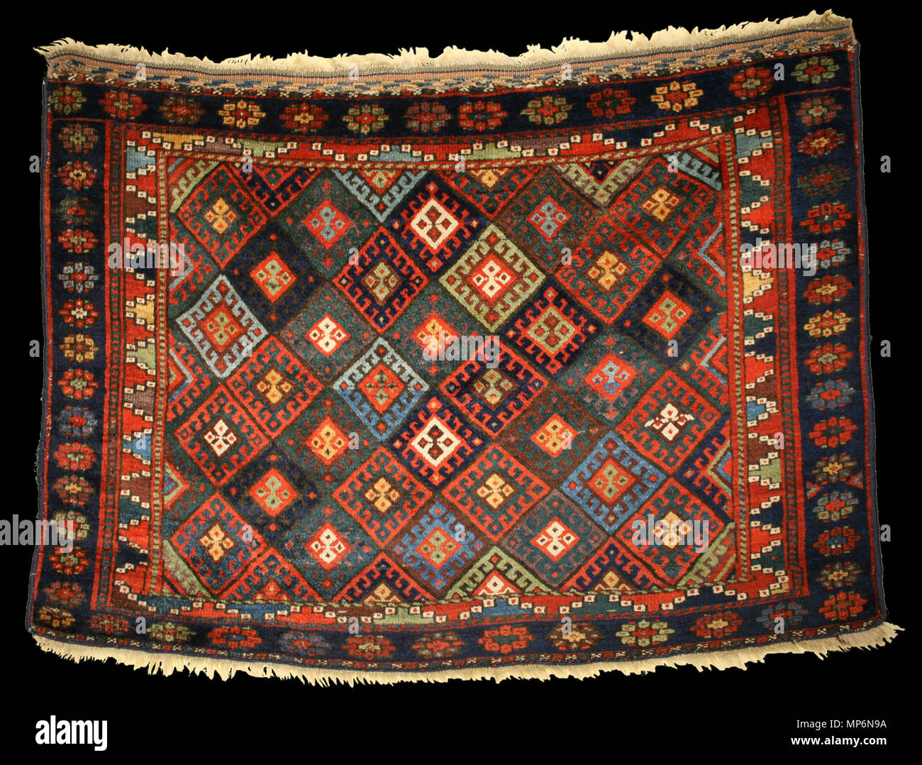 . English: Origin: Persian Jaf Kurdish Bag Size: 2.9 x 3.11 Date: ca. Mid 19th c The Jafs are a sub-tribe of the Kurdish and produce wonderfully distinctive diamond lattice pattern motifs on their rugs and bags. This bag-face has multiple rows of diamond motifs, each containing latch-hooks surrounding smaller crossed diamonds. The outer border is a single row of flowers. The whole piece is more colorful than most and is woven with exceptional wool. mid-19th century. Made by unknown Kurdish weaver. Photo by gallery 690 Jaf-Kurd bag Stock Photo