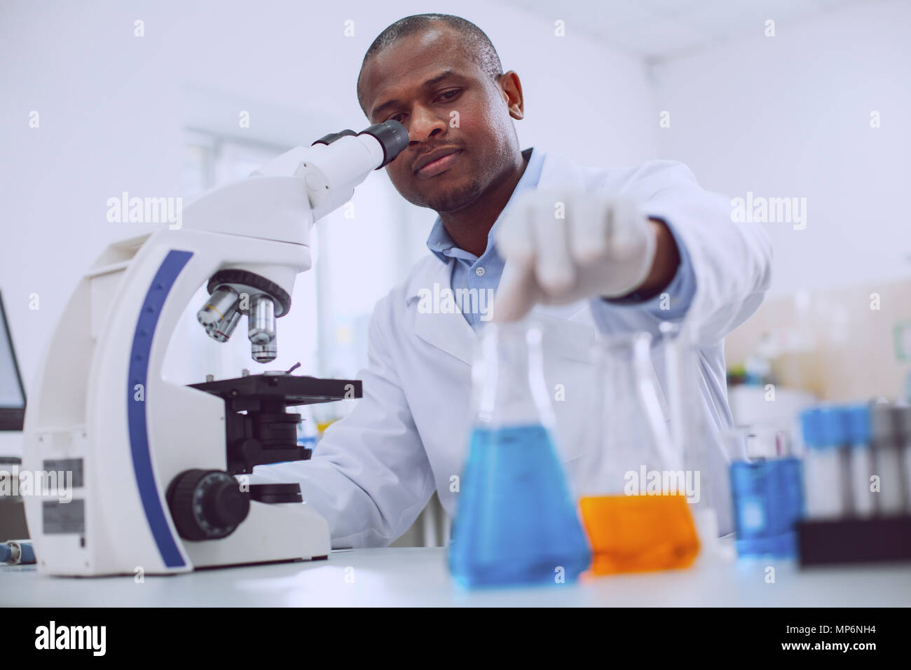 Serious biologist working with his microscope Stock Photo