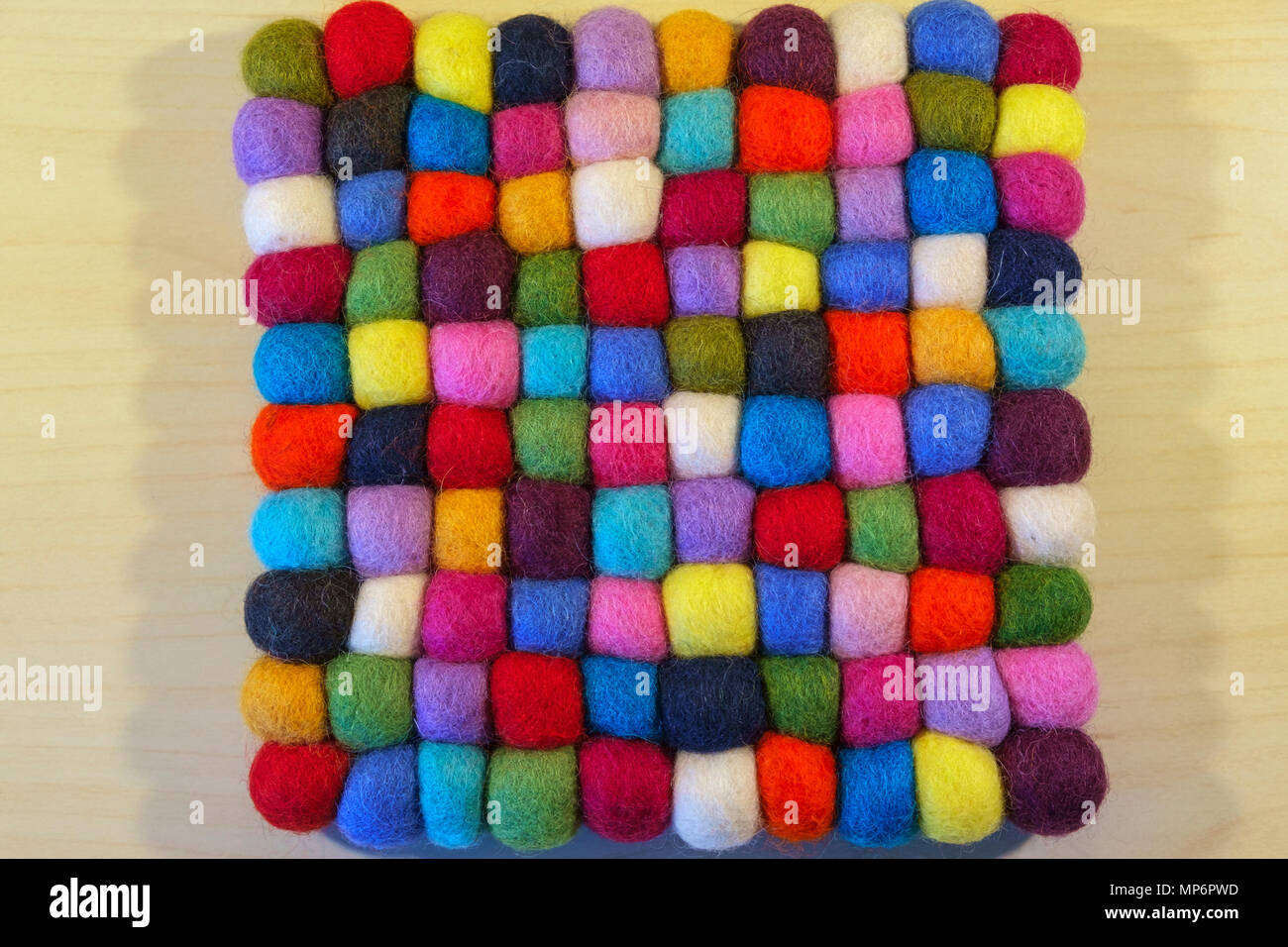 Close up full frame view of a vibrant multi coloured felt booble table mat Stock Photo