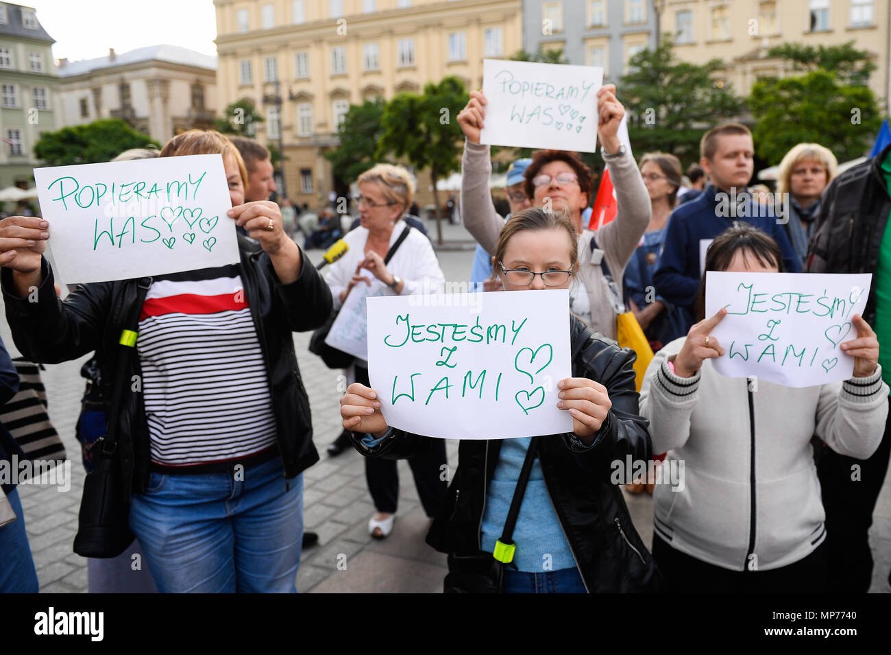 People holds banners during a  protest to show solidarity for the ongoing protest inside the Parliament by  parents of  disabled in Krakow. Stock Photo