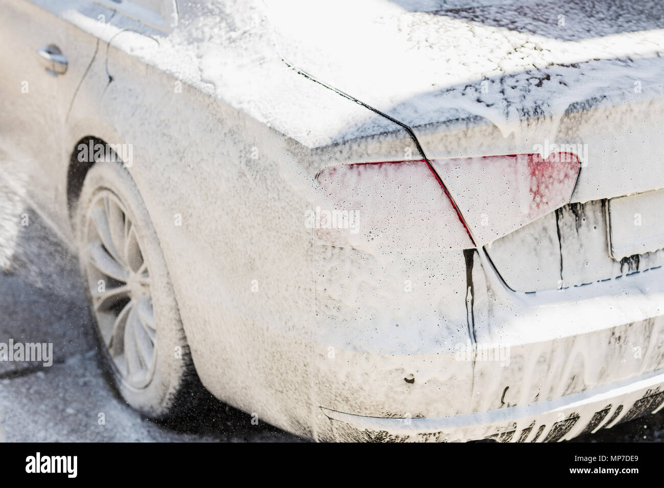 Manual car wash. Washing luxury vehicle with white foamy detergent