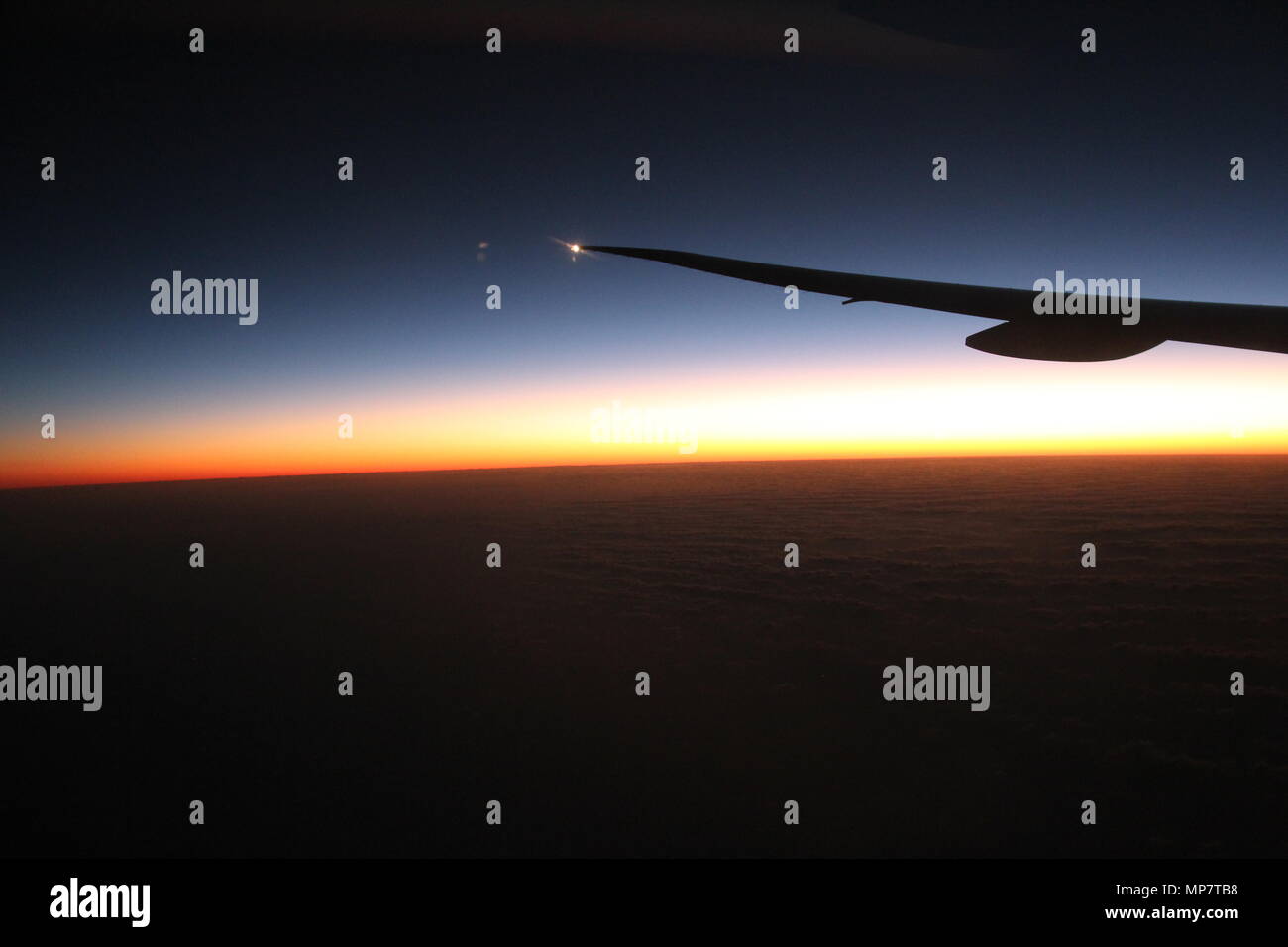 Airplane Jet Wing Flying Above The Clouds At Sunrise Stock Photo Alamy