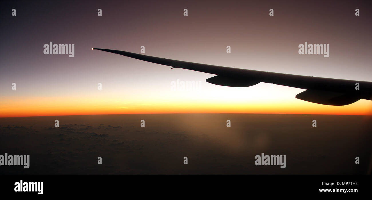 Airplane Jet Wing Flying Above The Clouds At Sunrise Stock Photo Alamy