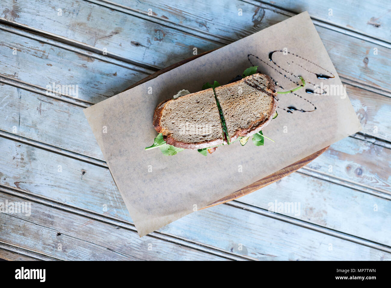Delicious sandwich drizzled with balsalmic vinegar on a wooden table Stock Photo