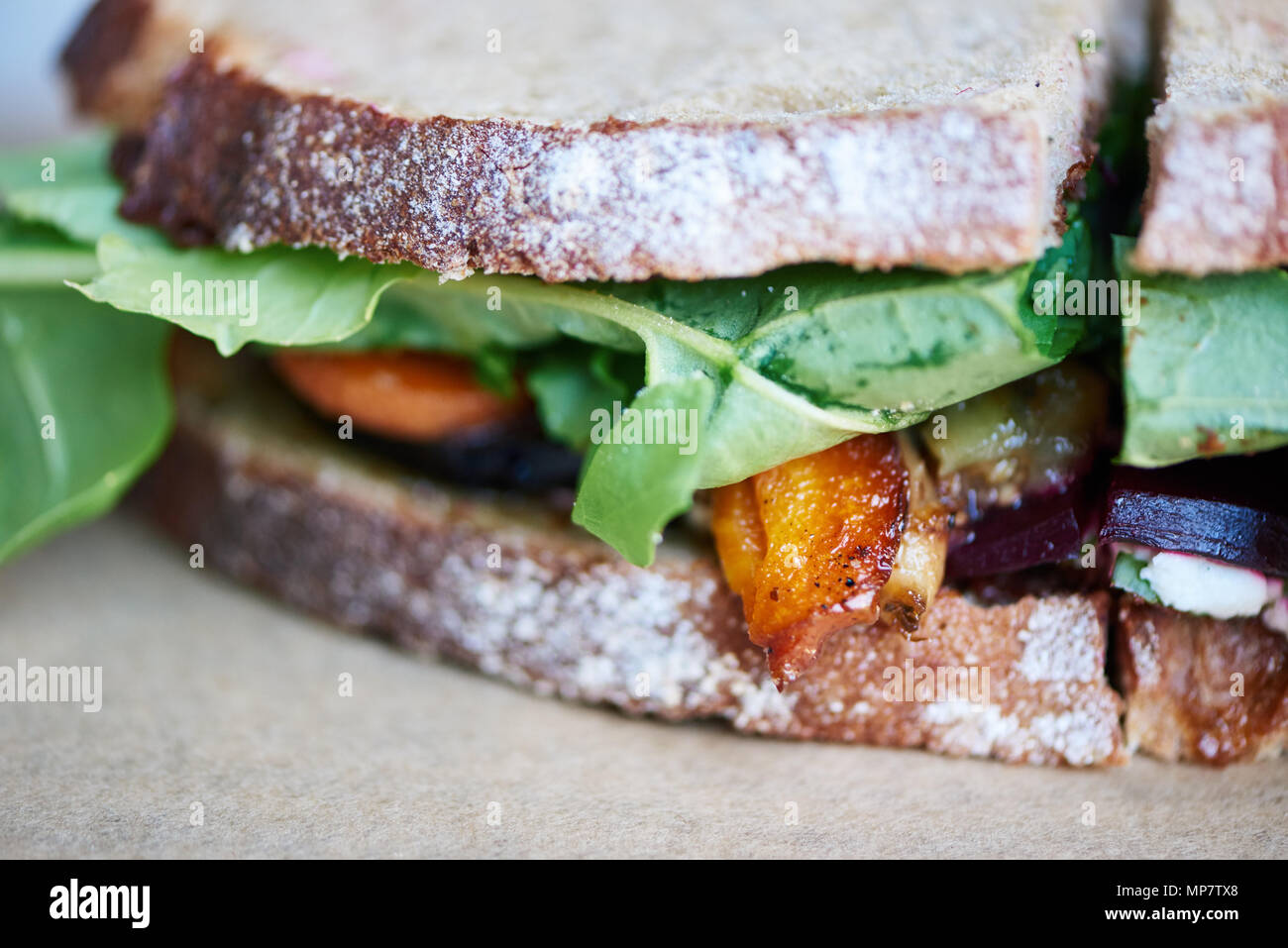 Gourmet mixed vegetable sandwich resting on a wooden table Stock Photo