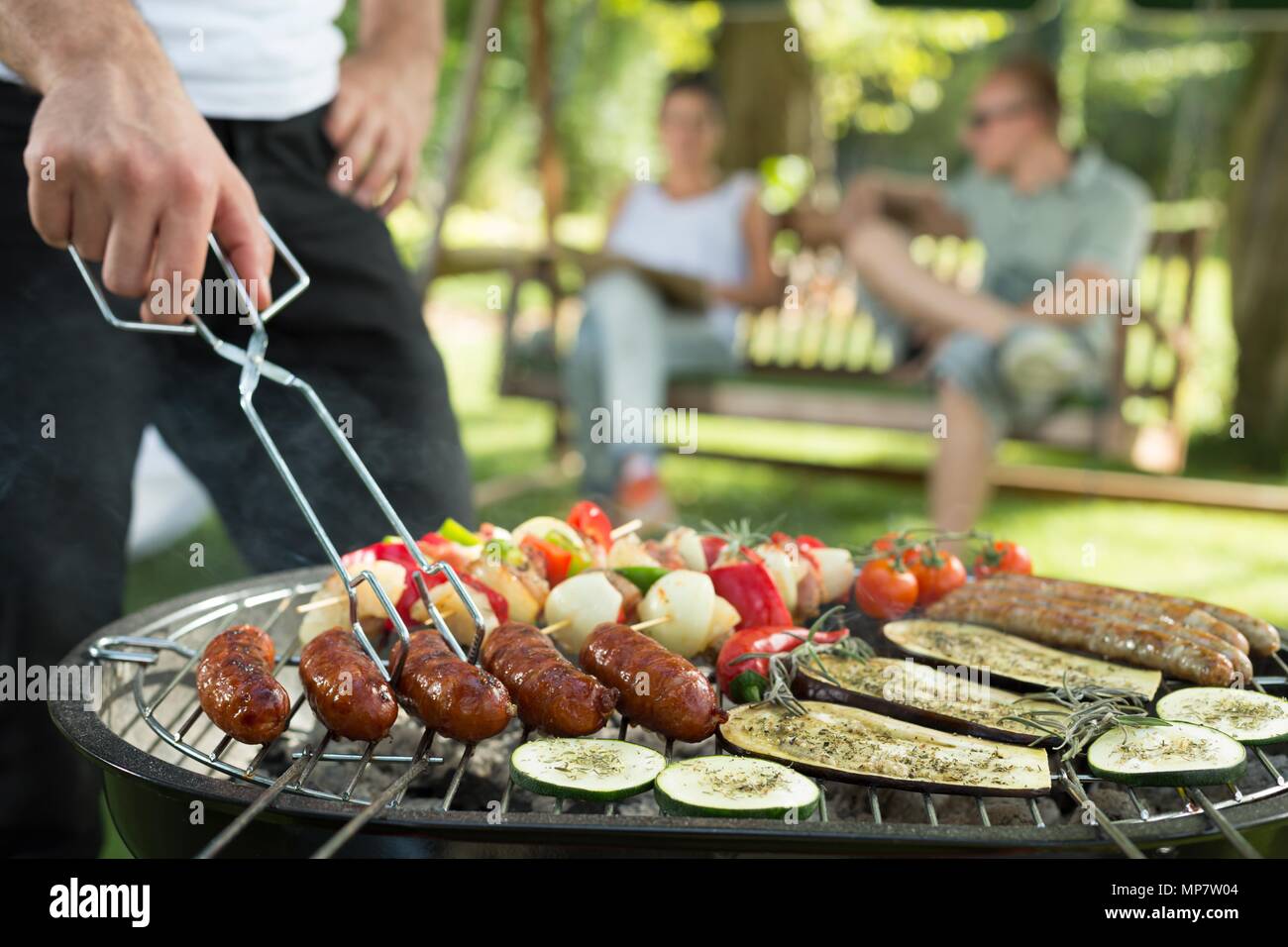 Grilling sausages and vegetables on bbq party Stock Photo
