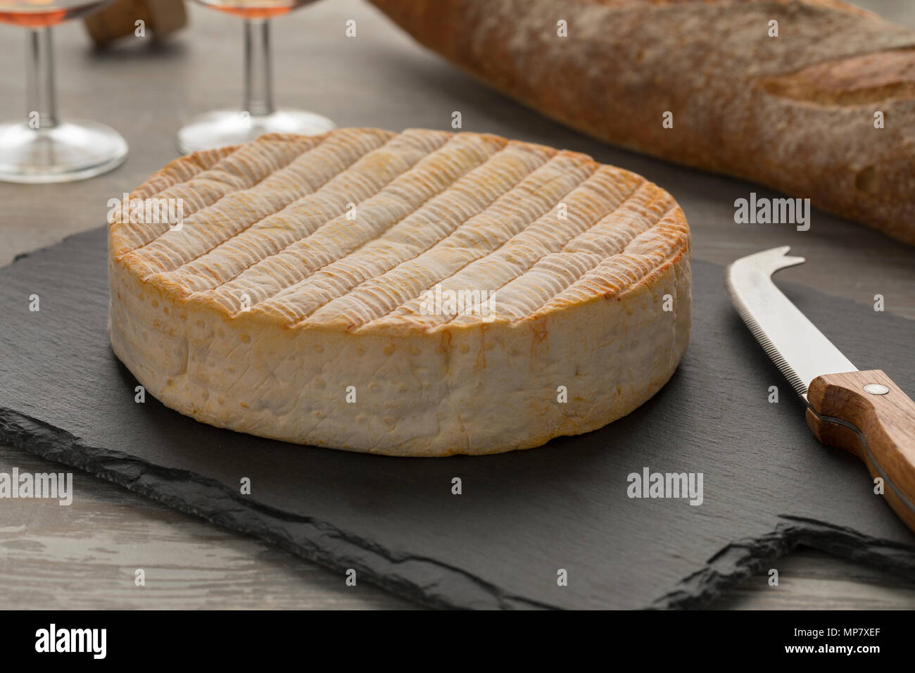 Whole  French Le Marcaire cheese on a slate cheeseboard Stock Photo