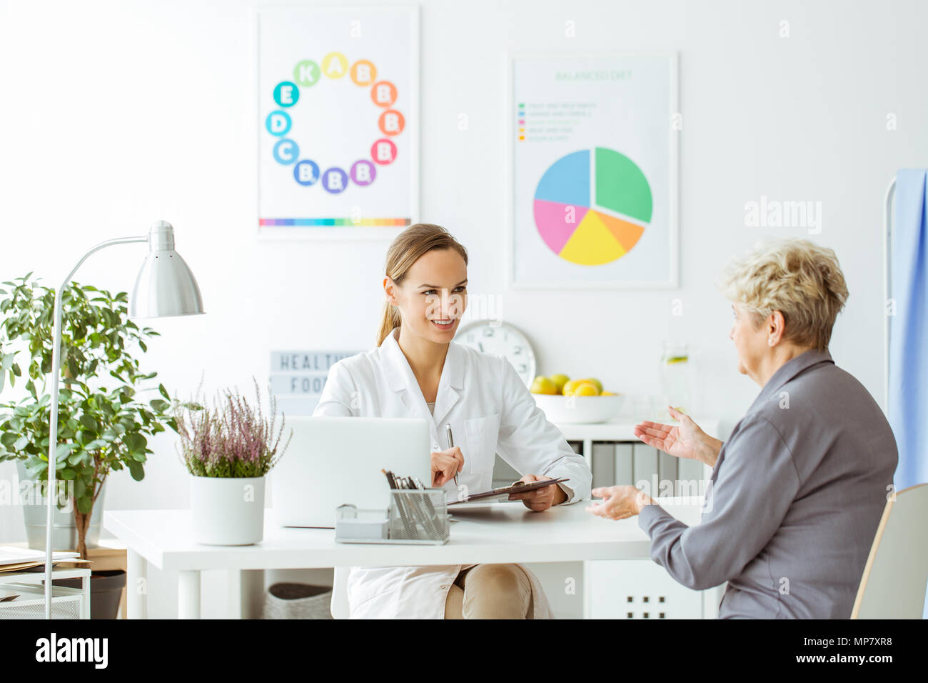 Smiling dietitian in uniform during consultation with a patient in