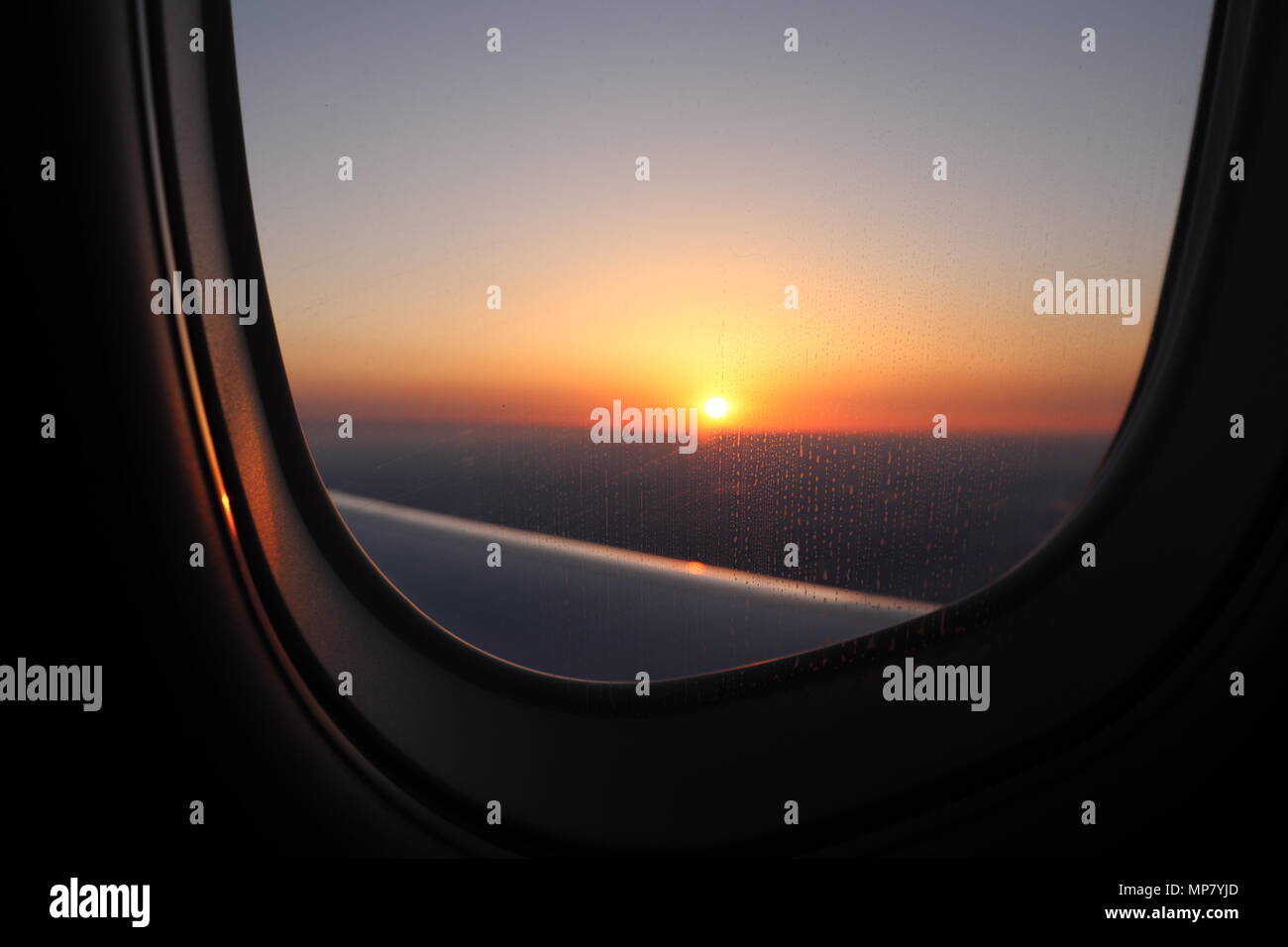 Sunset at JFK International Airport through the airplane window signifies the end of the journey and simultaneously the start of the better one Stock Photo
