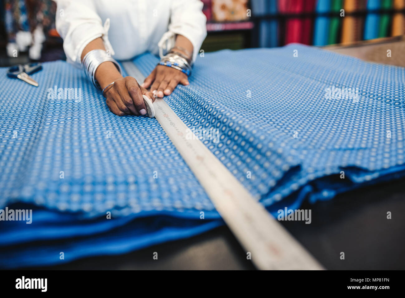 Closeup of a woman measuring cloth in her fabric shop Stock Photo