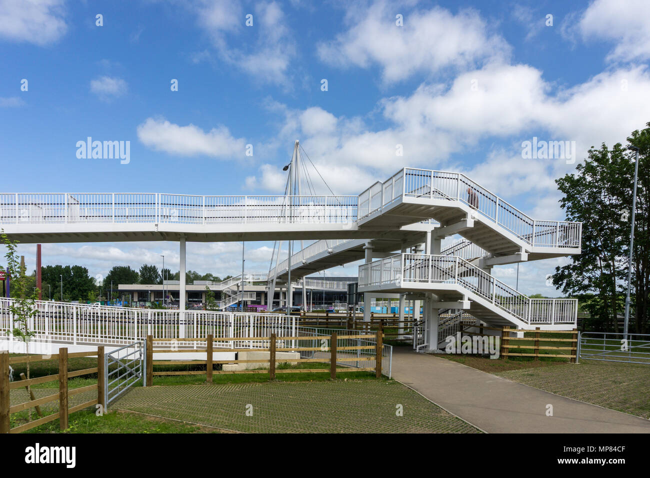 Modern pedestrian footbridge crossing the main A45 and leading to Rushden Lakes Shopping Centre, Northamptonshire, UK Stock Photo