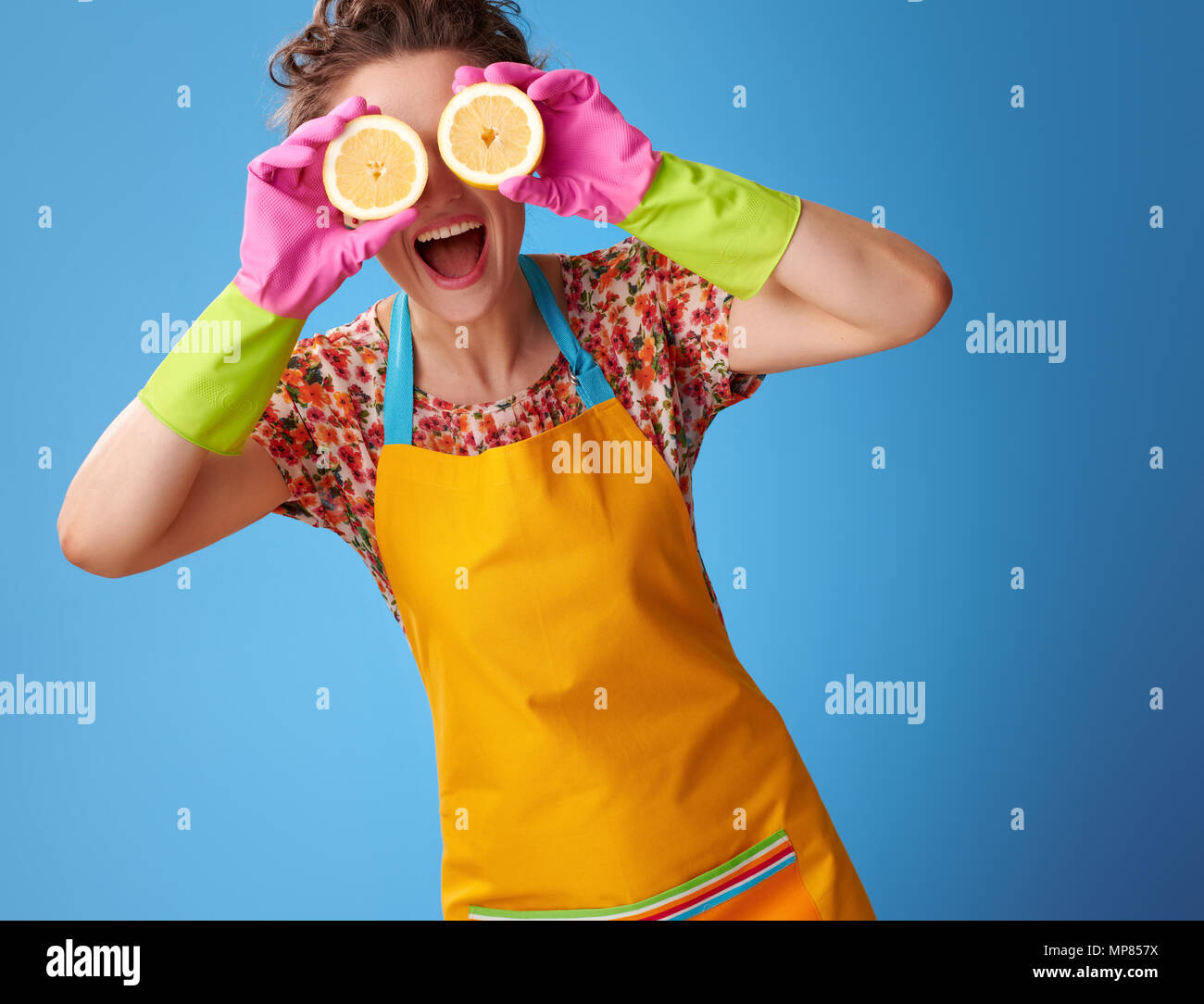 Big cleaning time. smiling modern housewife in a yellow apron holding ...