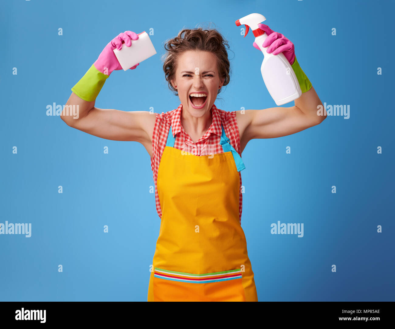 Big cleaning time. smiling modern housewife in a yellow apron with ...