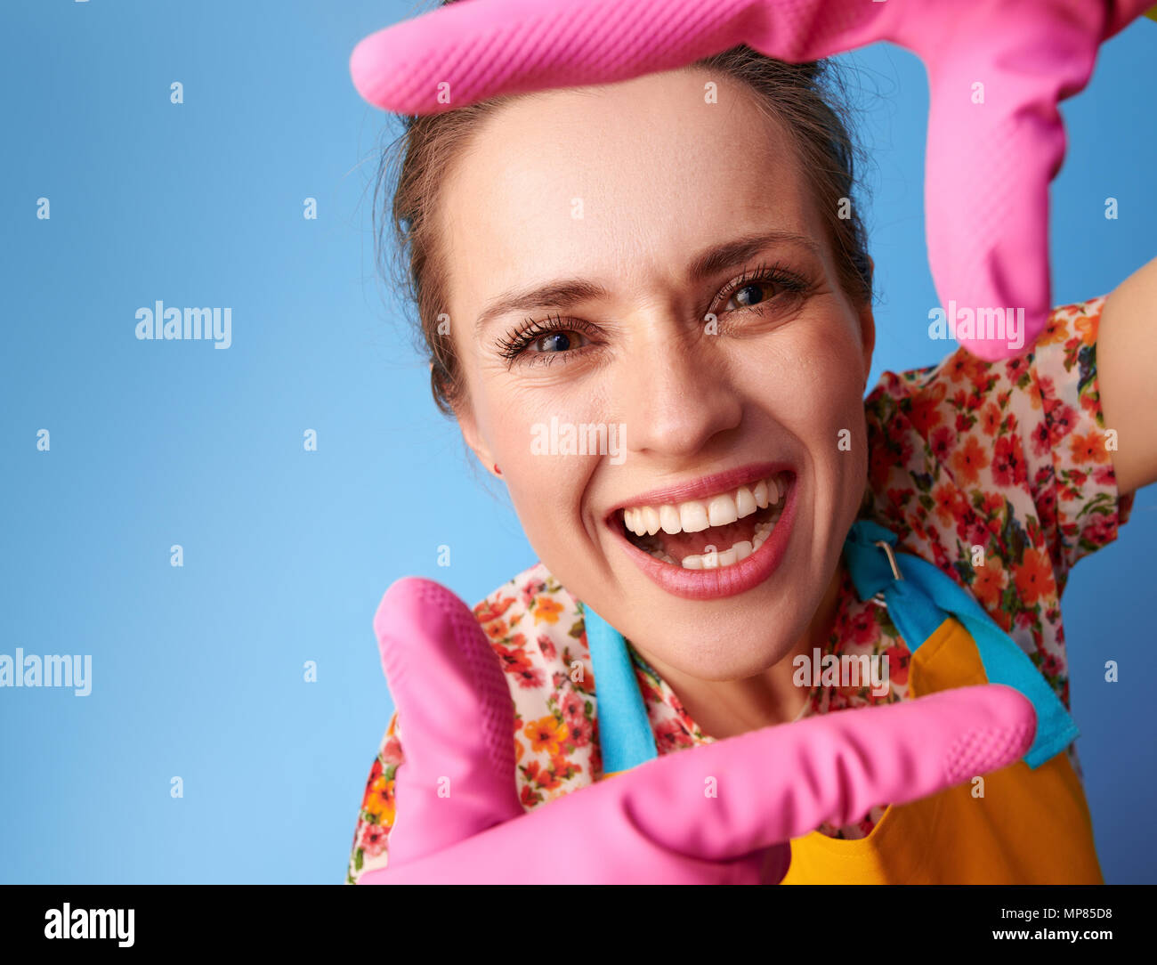 Big cleaning time. smiling modern housewife in a yellow apron with ...