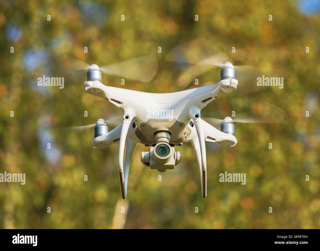 A DJI Phantom 4 Pro drone flying, trees in the background, selective focus  on front of the drone Stock Photo - Alamy