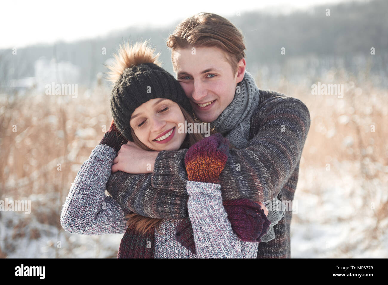 christmas happy couple in love embrace in snowy winter cold forest, copy space, new year party celebration, holiday and vacation, travel, love and relations Stock Photo