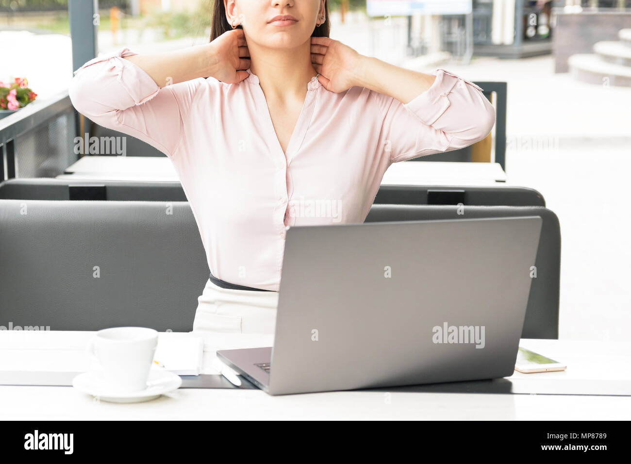 A tired woman massaging her neck at desktop in office Stock Photo - Alamy