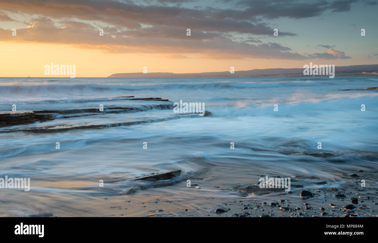 Dramatic beautiful sunset on a rocky coast. Long exposure photography Stock Photo