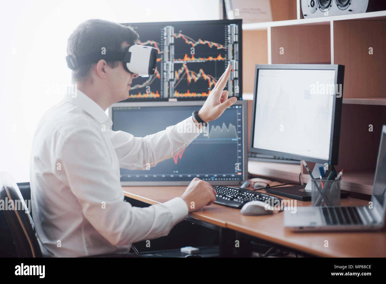 Businessman in virtual reality trading on stock market. Multiple ...