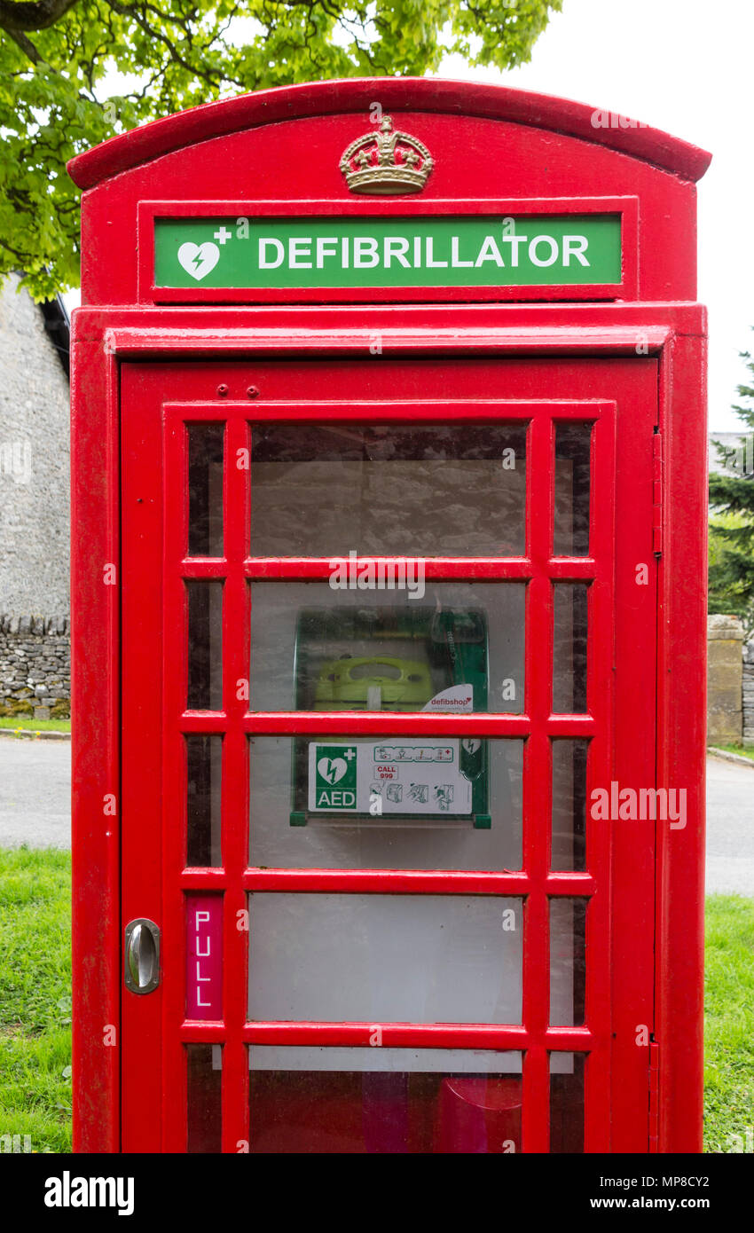Traditional red telephone box with a defibrillator hires stock