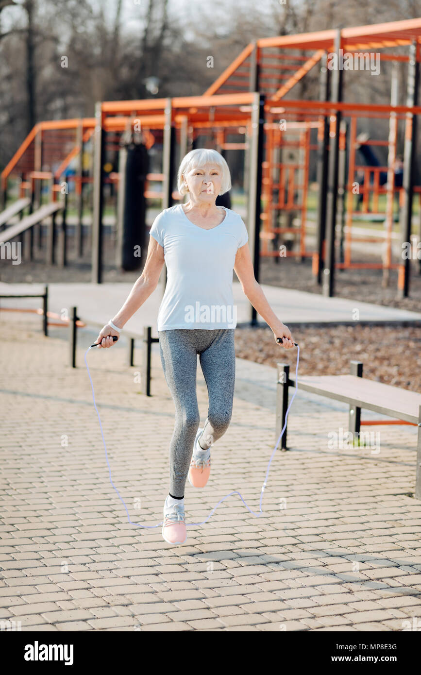 70 year old woman stays in good shape jump roping in the park in