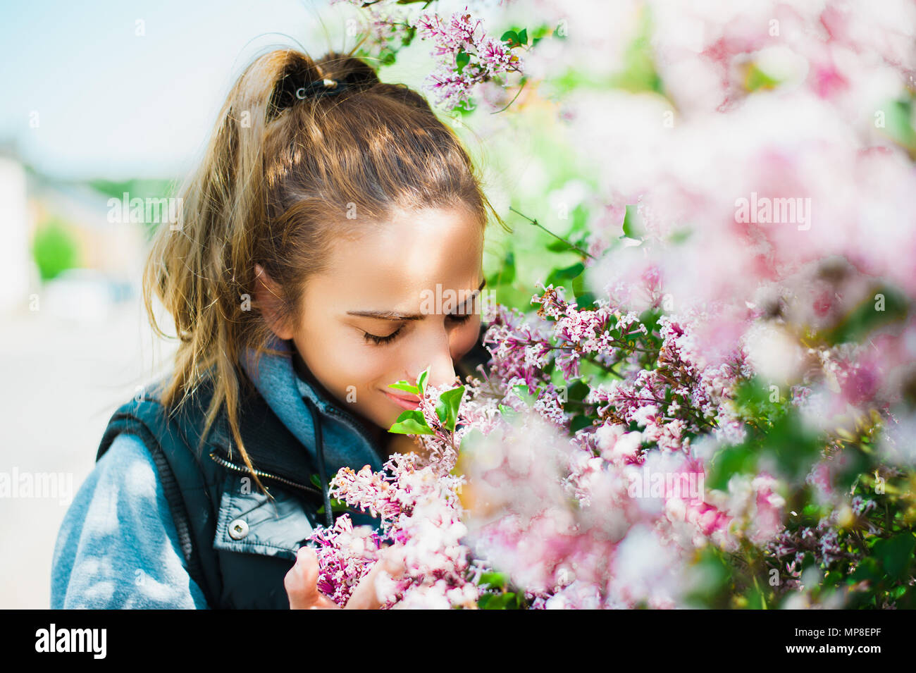 Beautiful, young woman smelling flowers Stock Photo