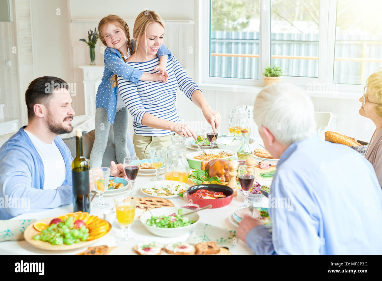 Happy Mother Serving Food at Family Dinner Stock Photo Alamy