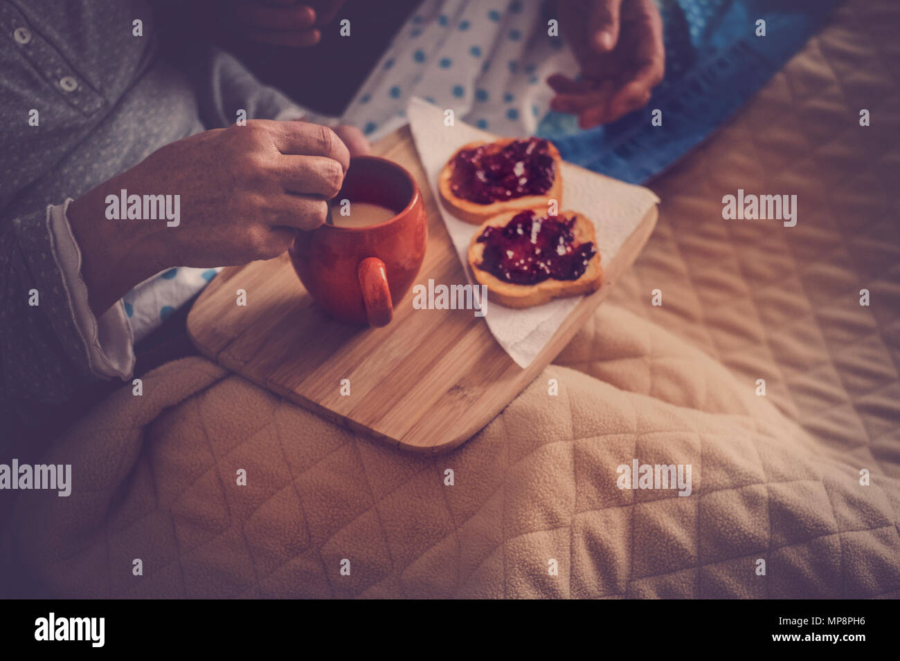bedroom brekfast colose up at home. senior couple eat marmelade and milk and then wake up and start a new nice day together. vintage filter and beauti Stock Photo