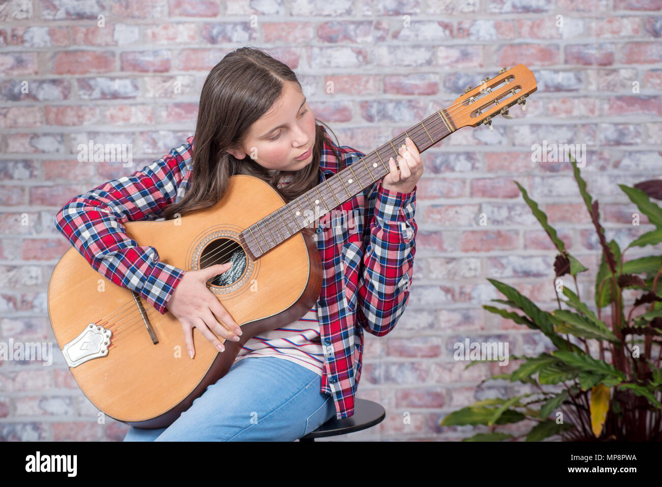 a smiling teenager girl playing an acoustic guitar Stock Photo - Alamy