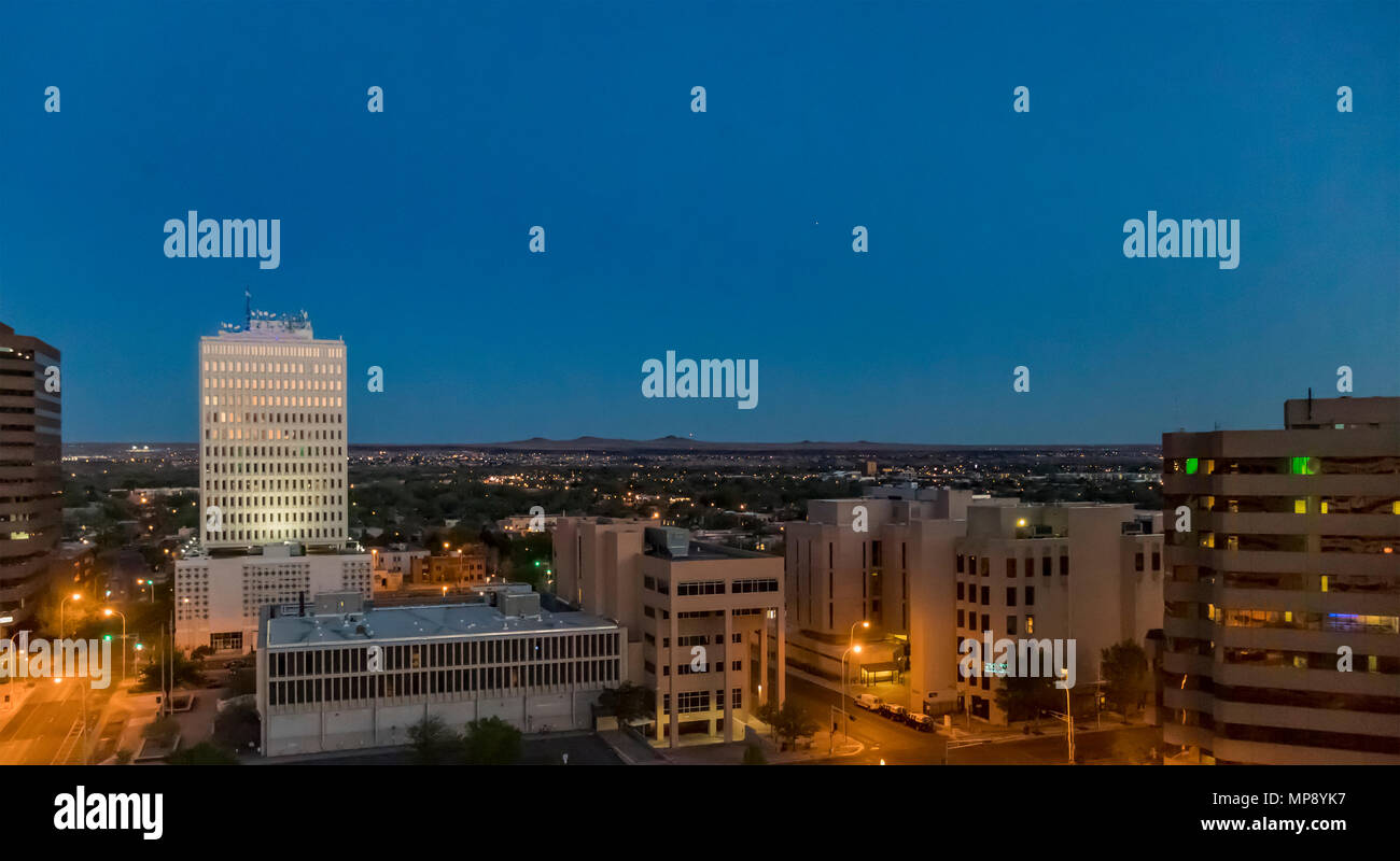 Albuquerque - view of downtown offices and the volcanoes of Petroglyph National Monument at twilight in springtime in Downtown Albuquerque, New Mexico Stock Photo