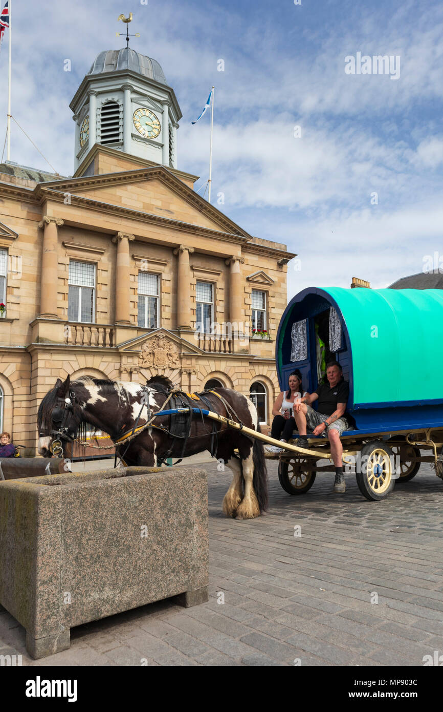 A travelling gypsy horse-drawn caravan parked in the market of Kelso, Scotland, with historic permission for genuine gypsy visitors to do this. Stock Photo