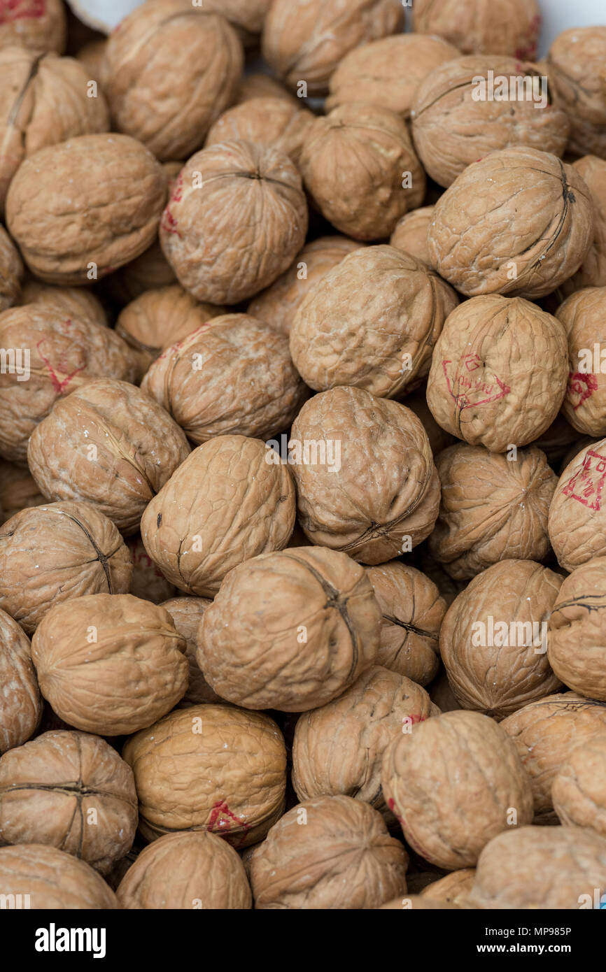 A large quantity of shell on walnuts on display at a market stall on