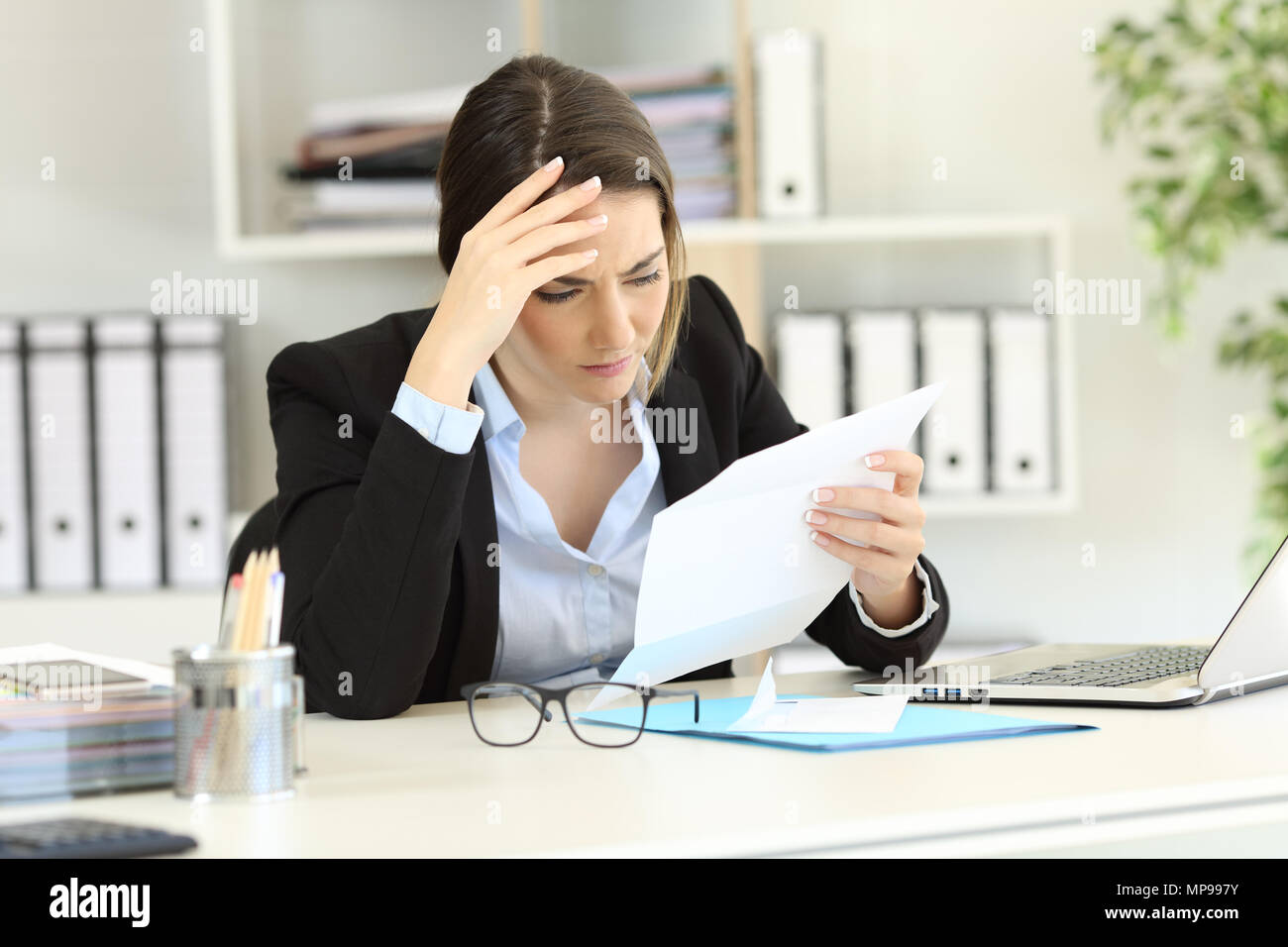 Worried executive reading bad news in a letter at office Stock Photo