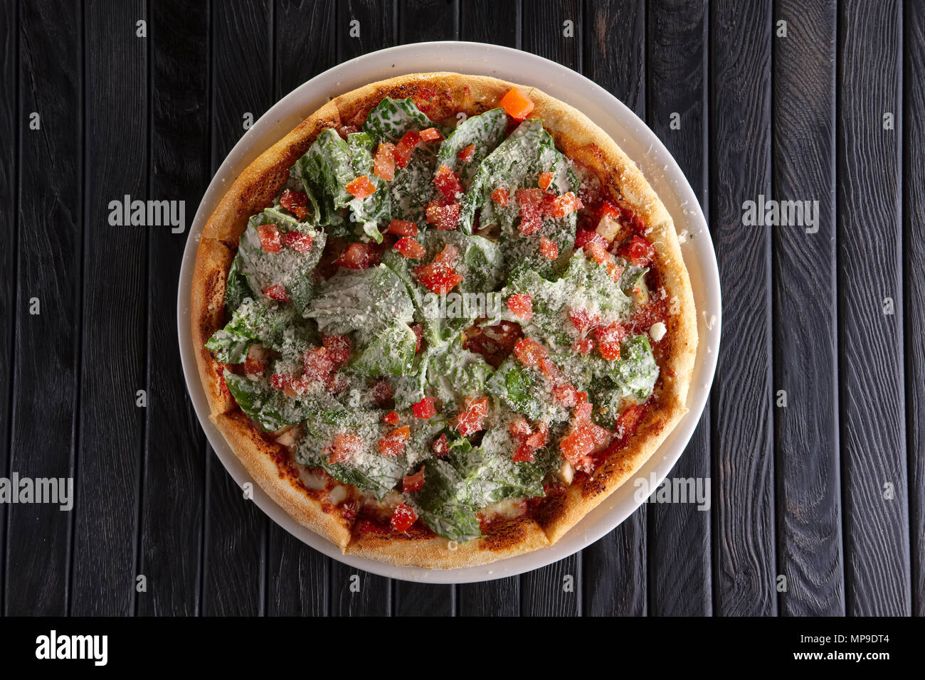 Top view of pizza with ham and green salad leaves arugula (salad rocket) Stock Photo