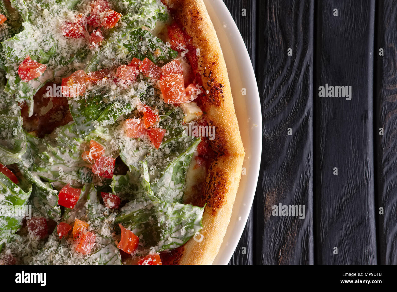 Top view of pizza with ham and green salad leaves arugula (salad rocket) Stock Photo