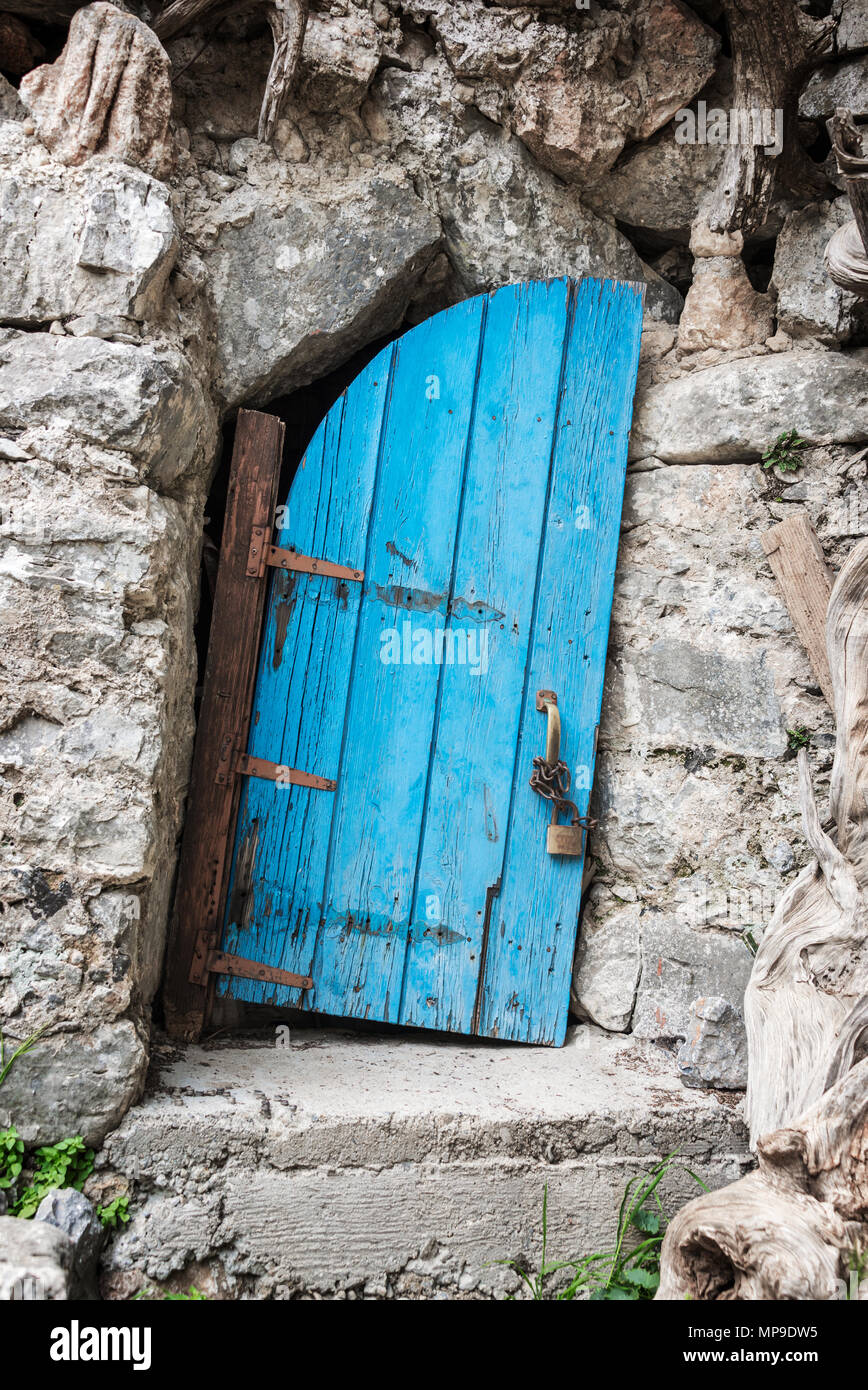 Old crooked blue wooden door in Crete, Greece Stock Photo