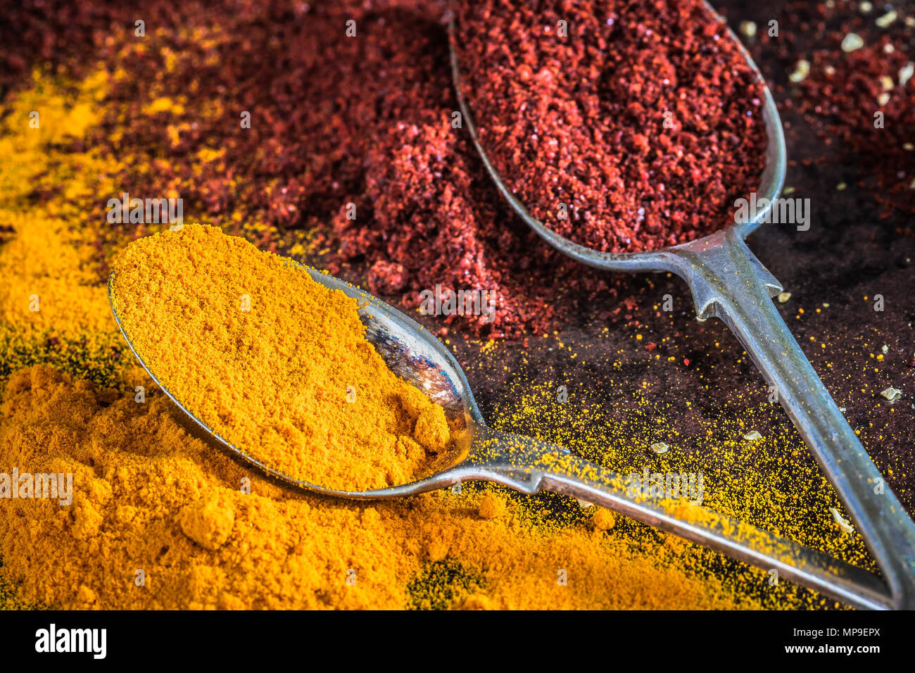 Various spices such as Turmeric & paprika on spoons, close up Stock Photo