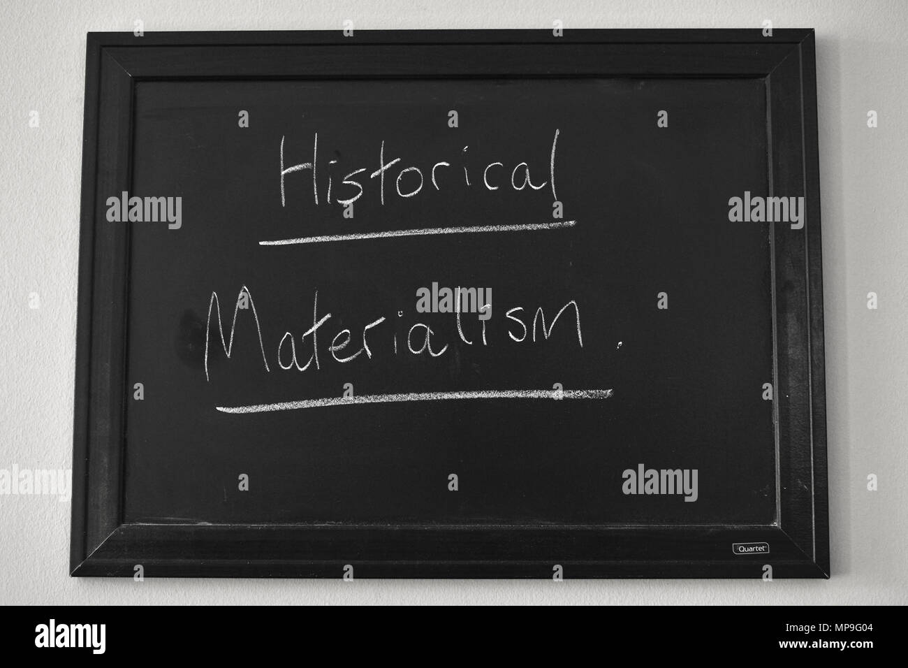 Historical Materialism written in white chalk on a wall mounted blackboard. Stock Photo