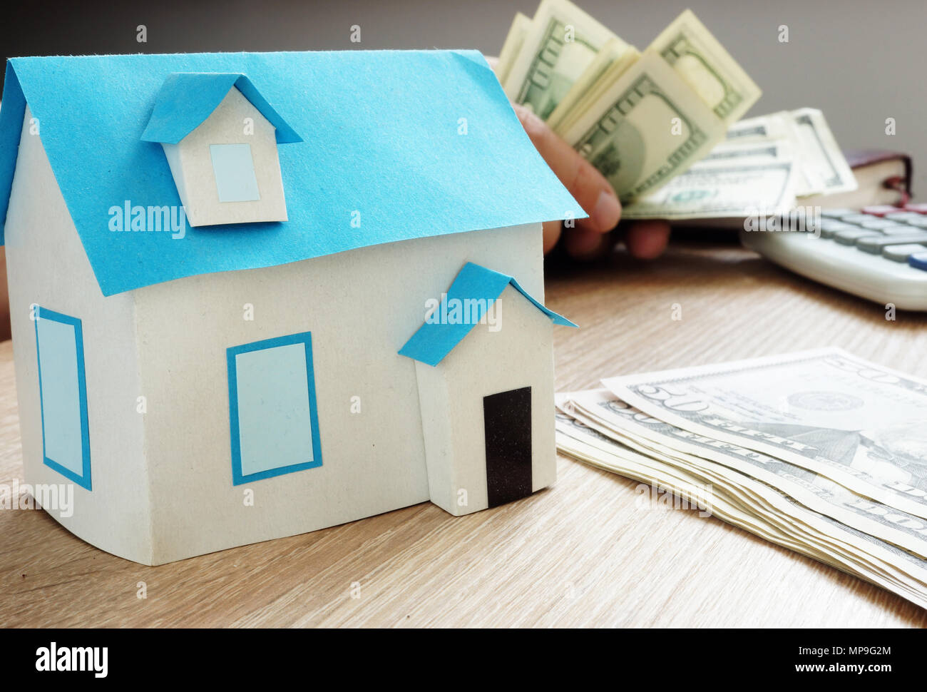 Mortgage concept. Model of house and dollars. Real estate loan. Stock Photo