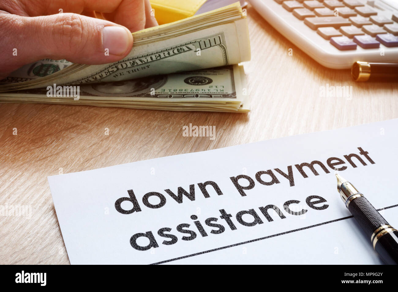 Down payment assistance form and dollar banknotes. Stock Photo
