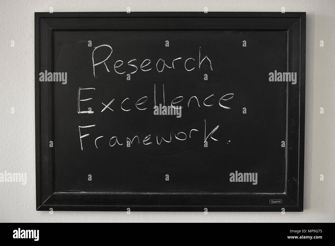 Research Excellence Framework written in white chalk on a wall mounted blackboard. Stock Photo