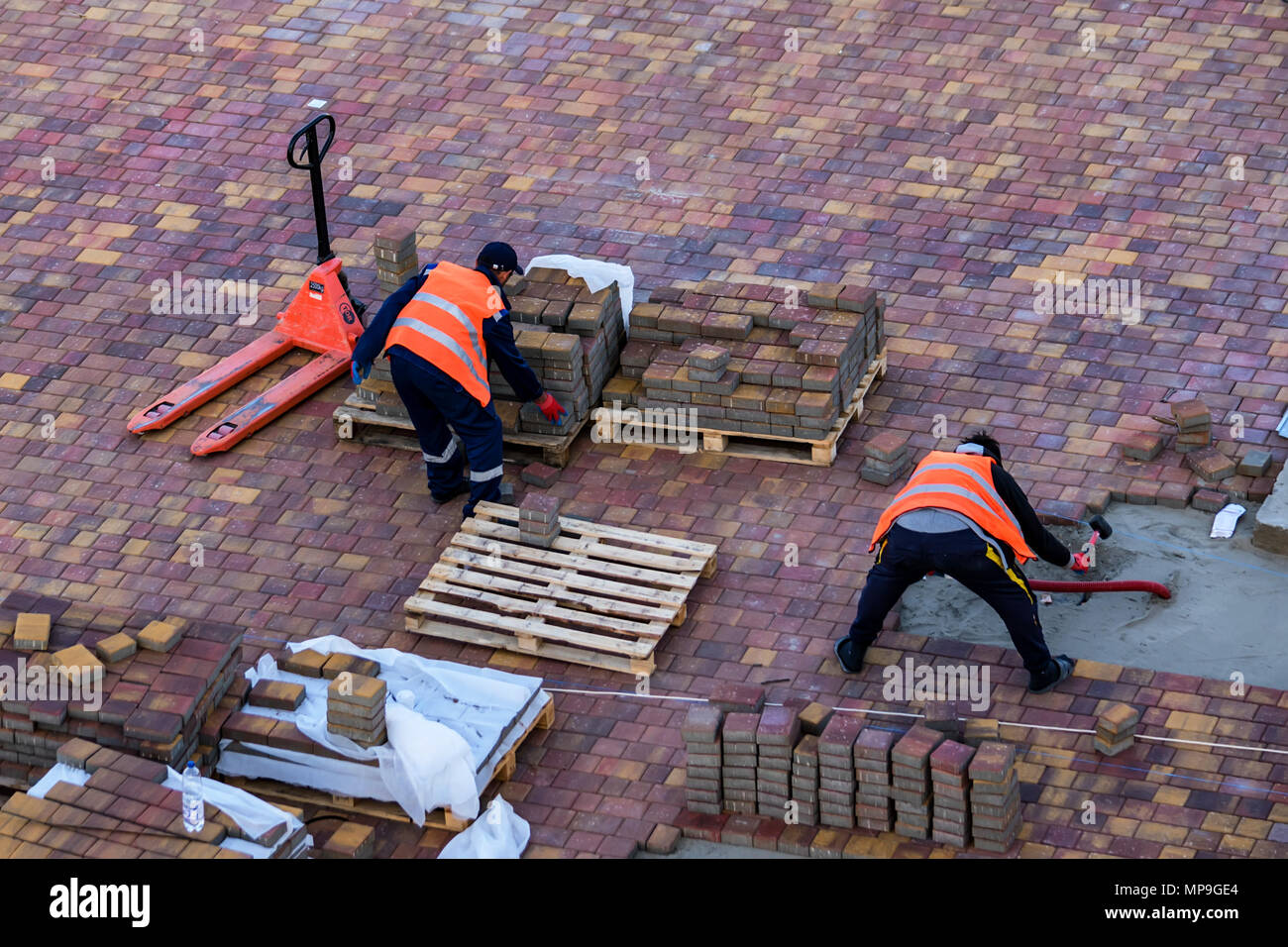 Workers pave sidewalk Stock Photo
