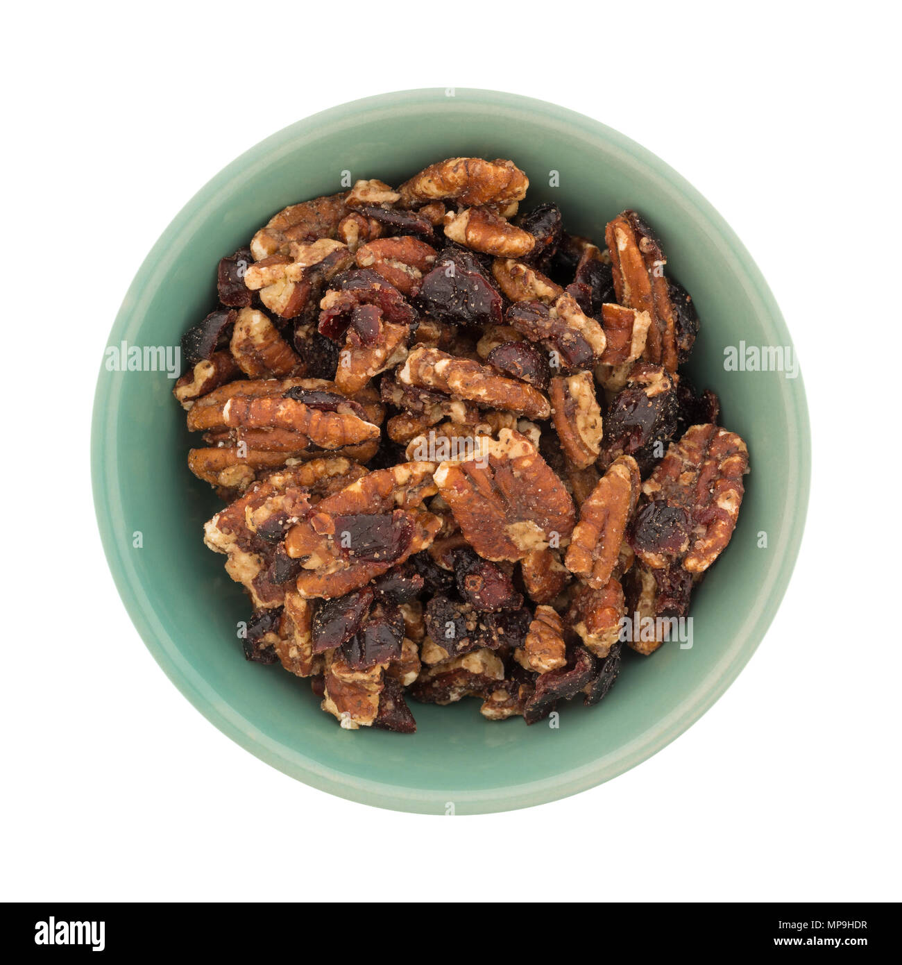 Top view of an old bowl filled with sugar glazed pecans and dried