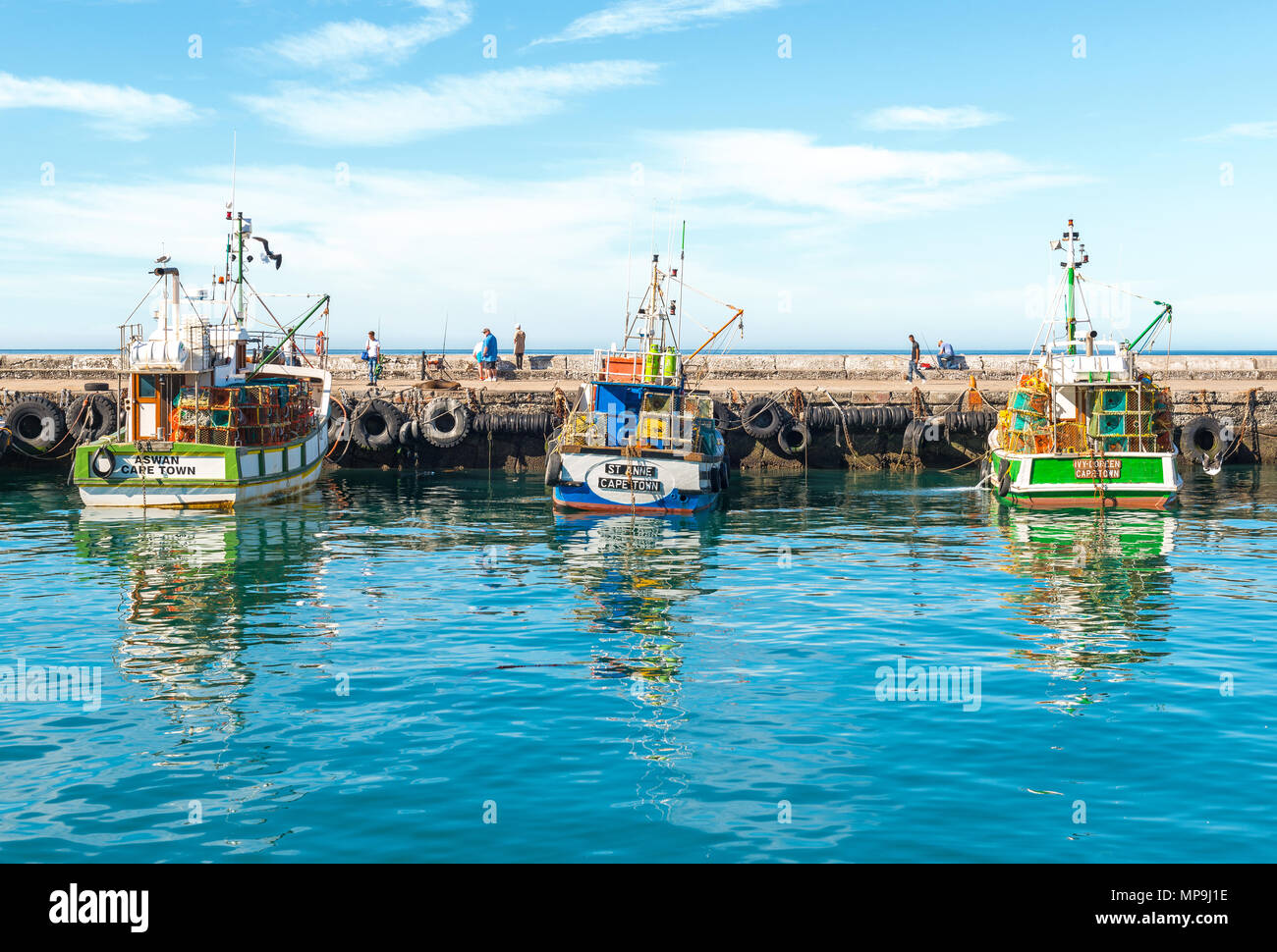 Fishing boats in the harbor of Kalk Bay in the early morning with fishermen in the background, Cape Town, Western Cape Province, South Africa. Stock Photo